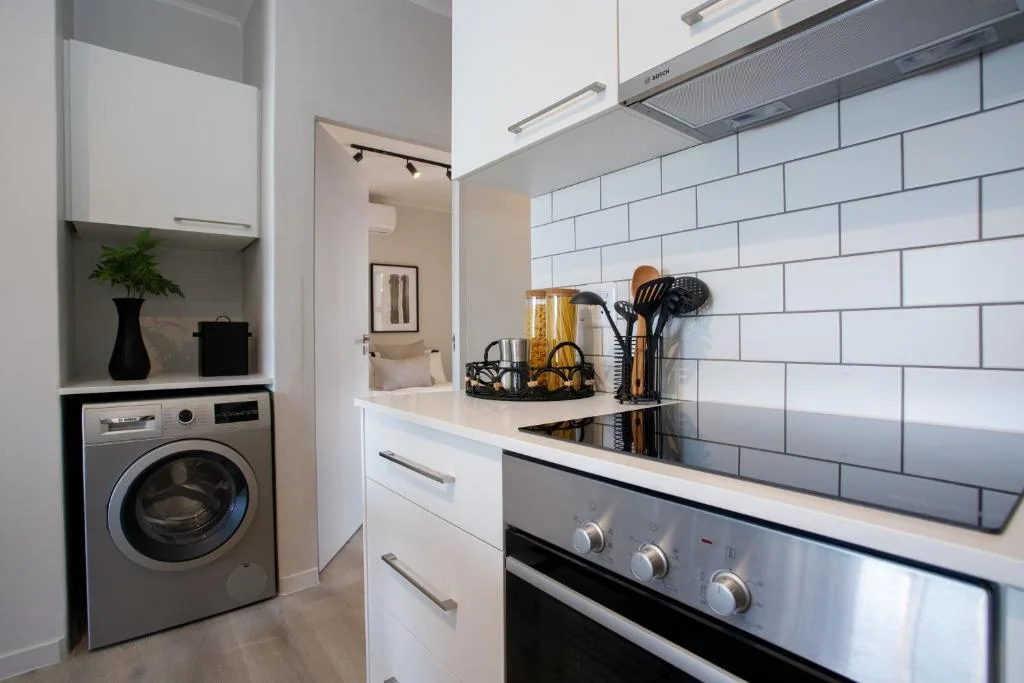 Modern kitchen with white cabinetry, subway tile backsplash, stainless steel oven