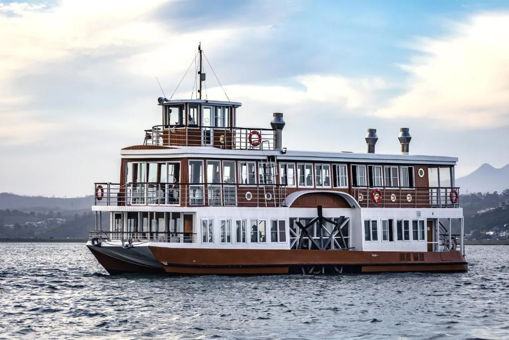 Scenic water view of historic paddle steamer boat on calm lagoon