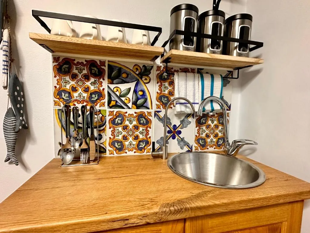 Decorative kitchen shelf with colorful tiles, utensils, and storage containers