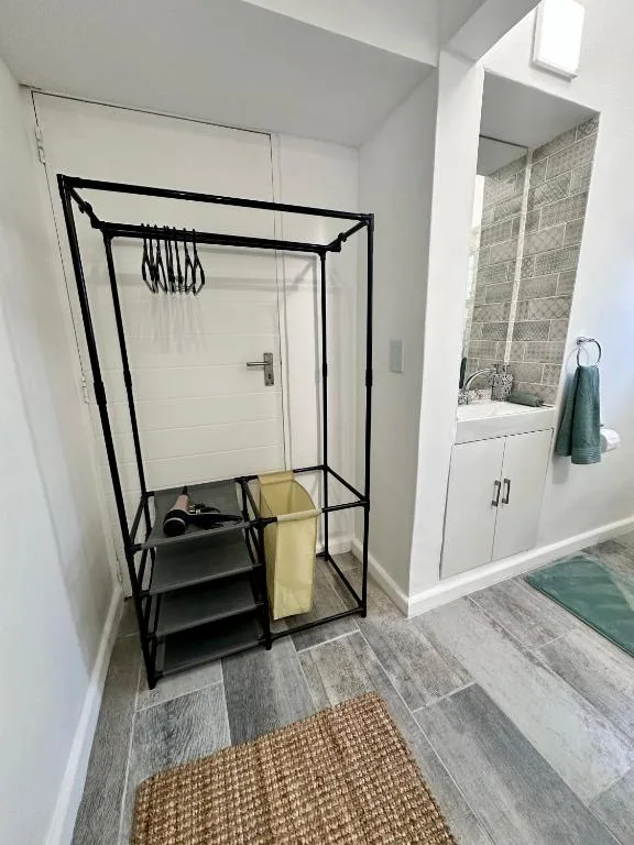 Modern bathroom with walk-in shower, vanity, and wood-look flooring