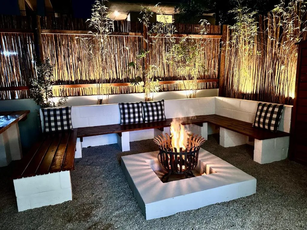 Evening firepit seating area with built-in benches and checkered cushions