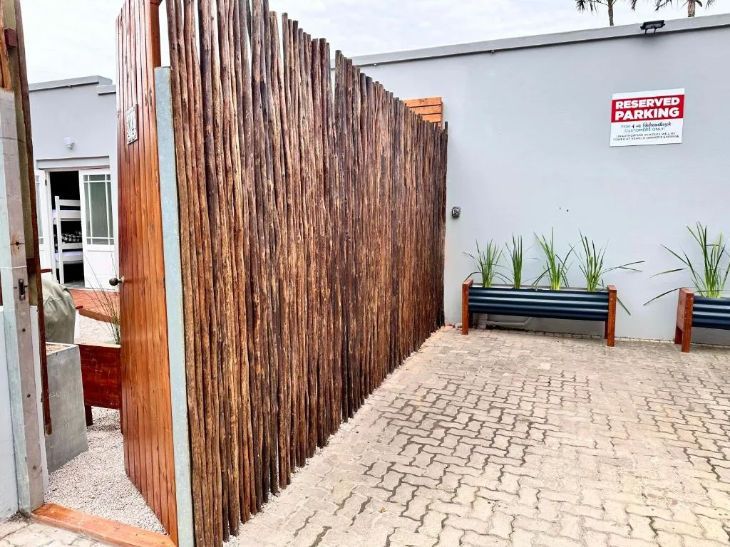 Modern apartment exterior with wooden fence and reserved parking sign