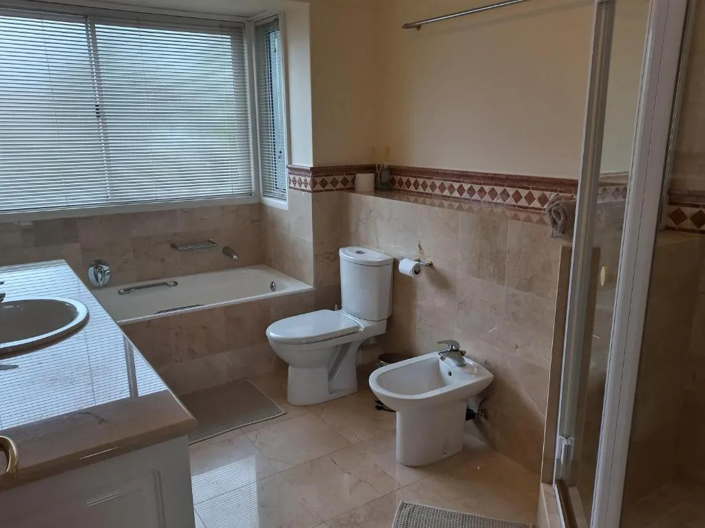 Spacious bathroom with bathtub, toilet, bidet, and vanity sink