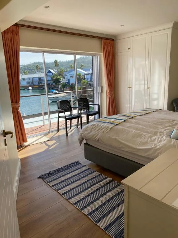 Spacious bedroom with waterfront view through sliding glass doors