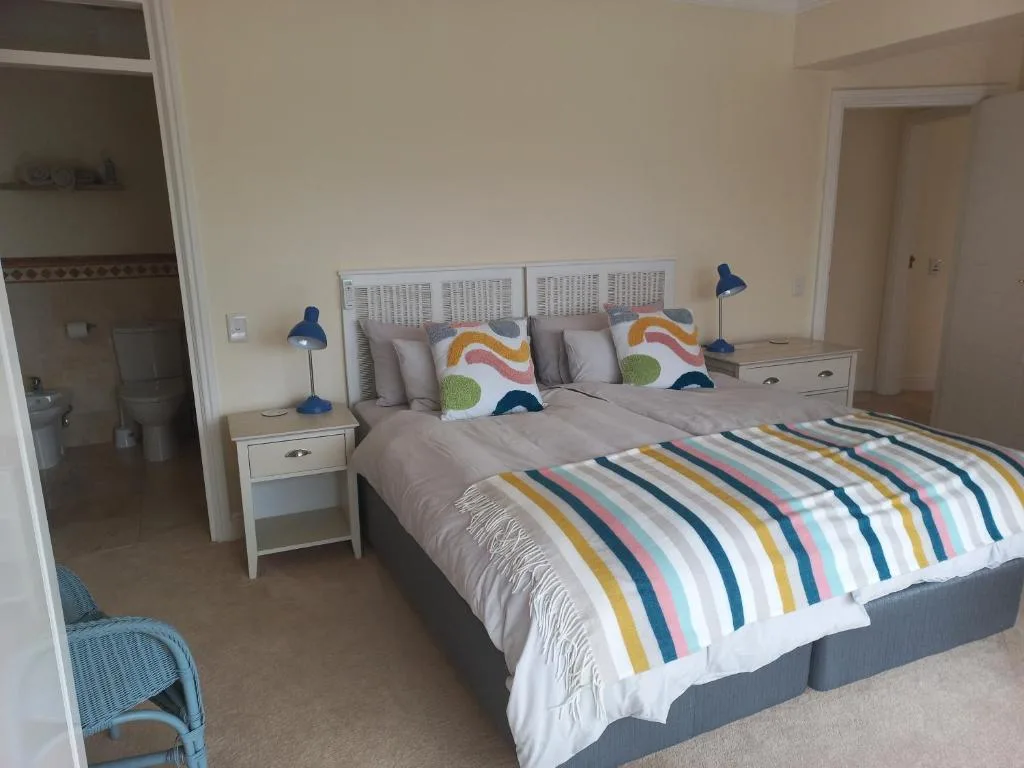 Bright bedroom with colorful striped bedding and blue accent lamps