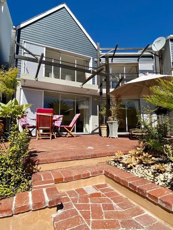Brick patio with lounge chairs and pergola attached to modern home