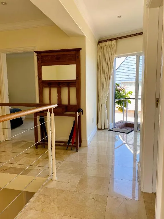 Bright hallway with tile flooring and door opening to deck area