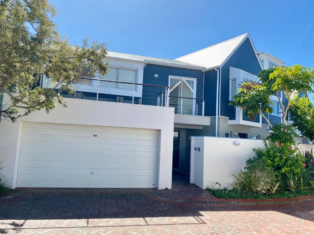 Modern two-story beach house with white garage and blue upper facade