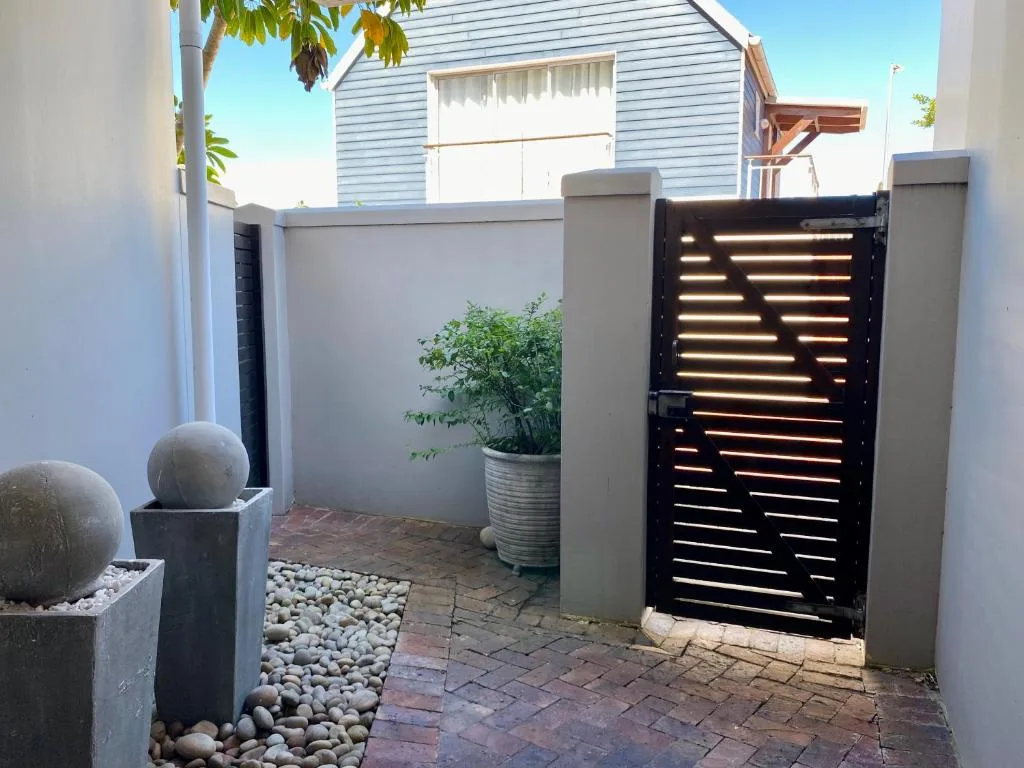 Modern courtyard entrance with contemporary gate and decorative planters