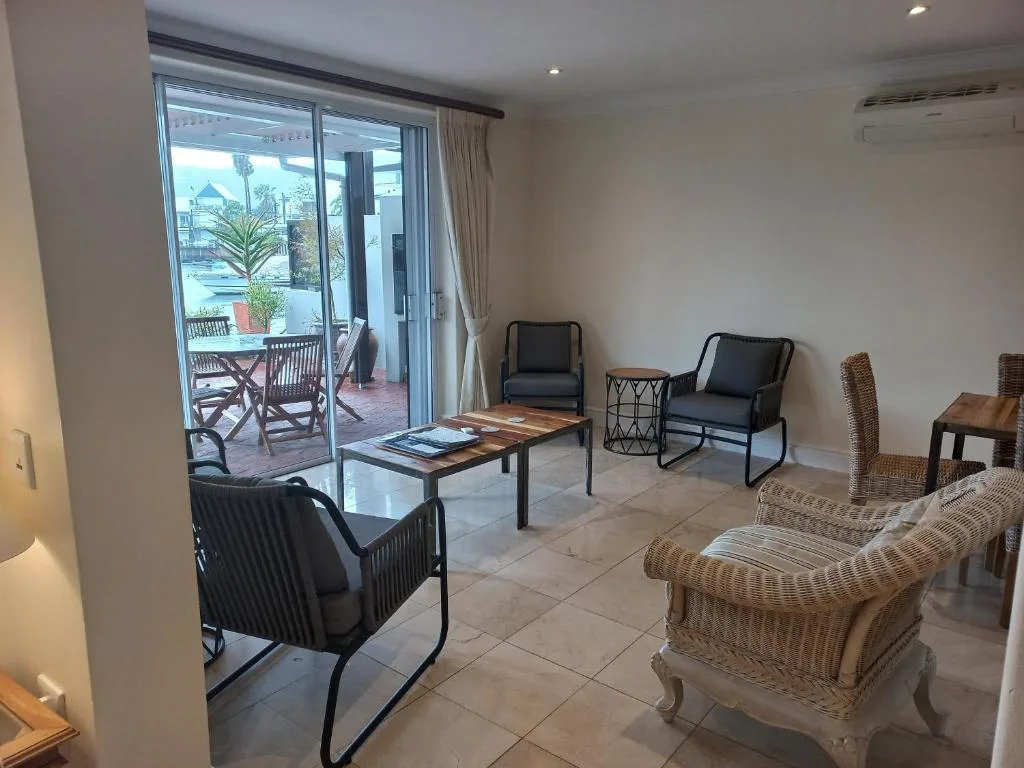 Spacious lounge with wicker chairs, seating area, and garden view doors