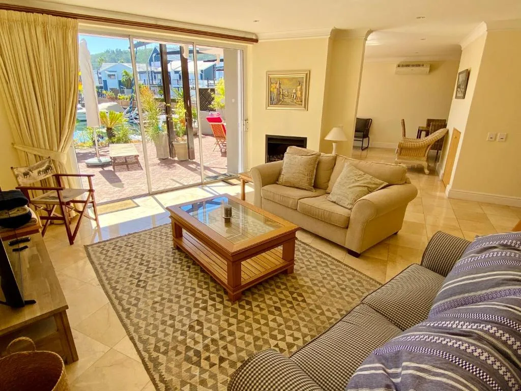 Spacious lounge with cream sofas, fireplace, and garden view doors