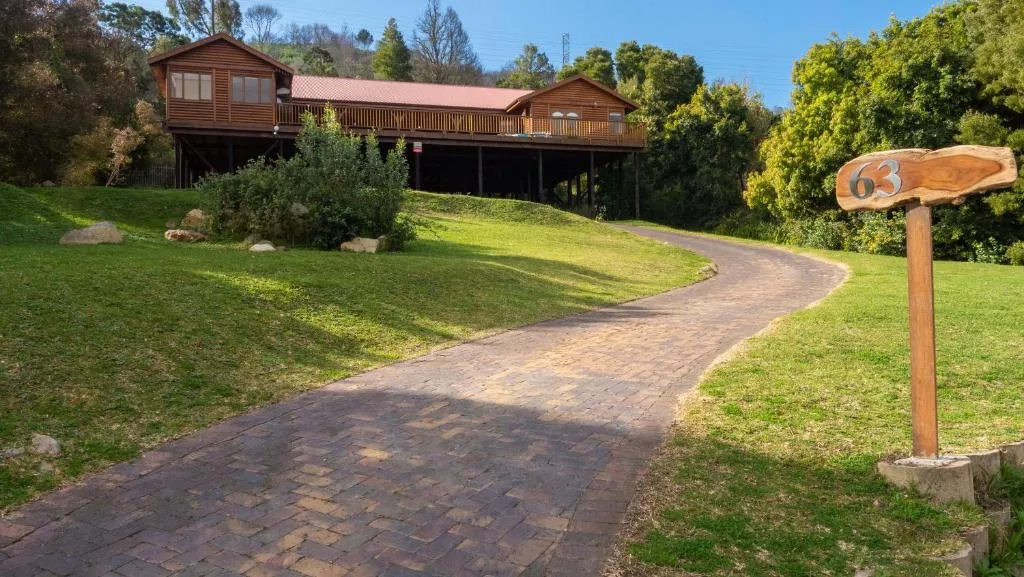 Wooden garden route home on hillside with brick pathway and lush grounds