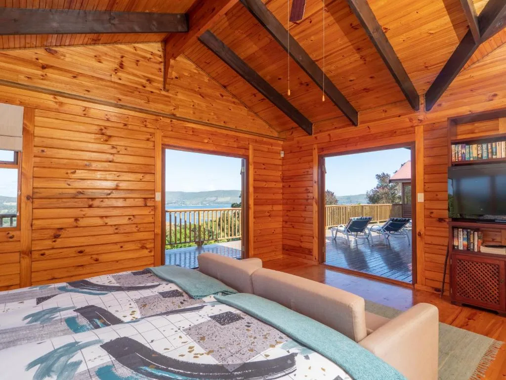Spacious wooden lounge with sofa overlooking deck and lagoon views