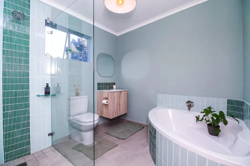 Modern bathroom with walk-in shower, freestanding tub, and wooden vanity