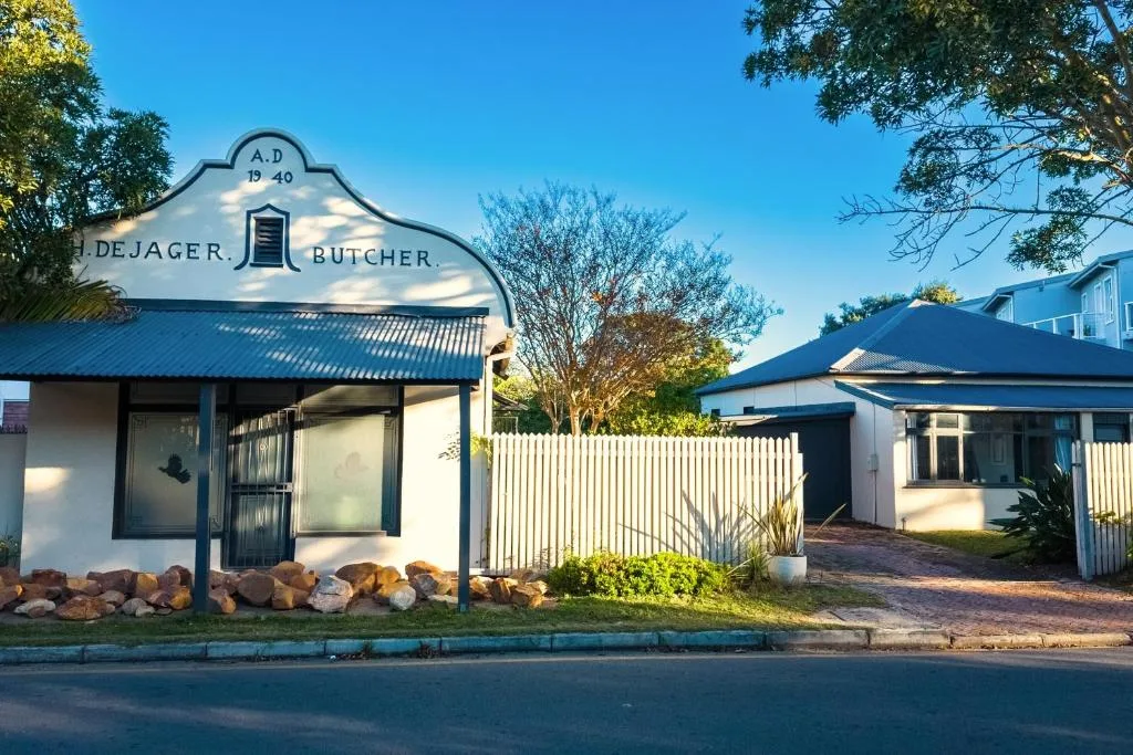 Historic white cottage with distinctive gabled roof and blue trim entrance