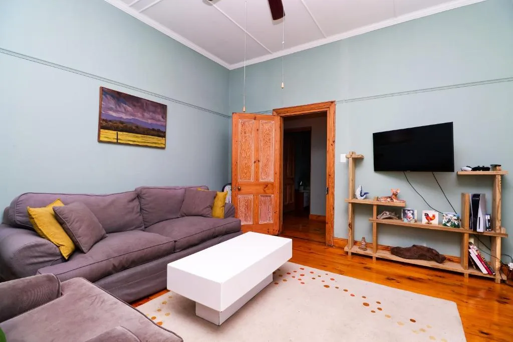 Modern lounge with purple sectional sofa, white coffee table, and wall-mounted TV
