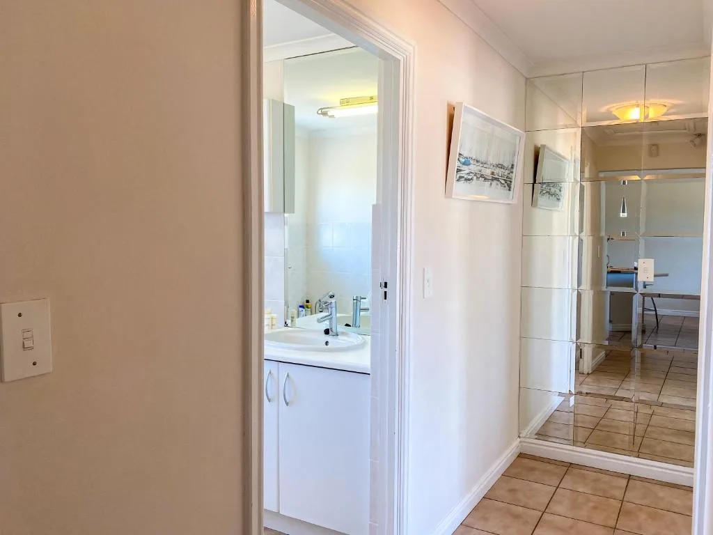 Modern bathroom with white vanity, sink, and large mirror cabinet