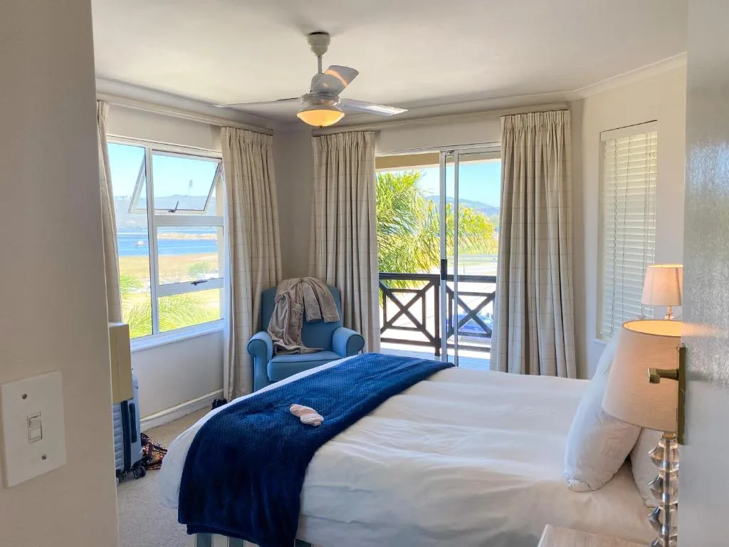 Spacious bedroom with ocean views through sliding glass doors and windows