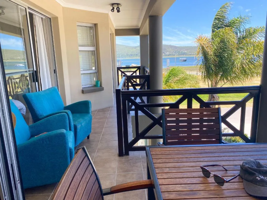 Spacious balcony with blue armchair overlooking Knysna lagoon and mountains