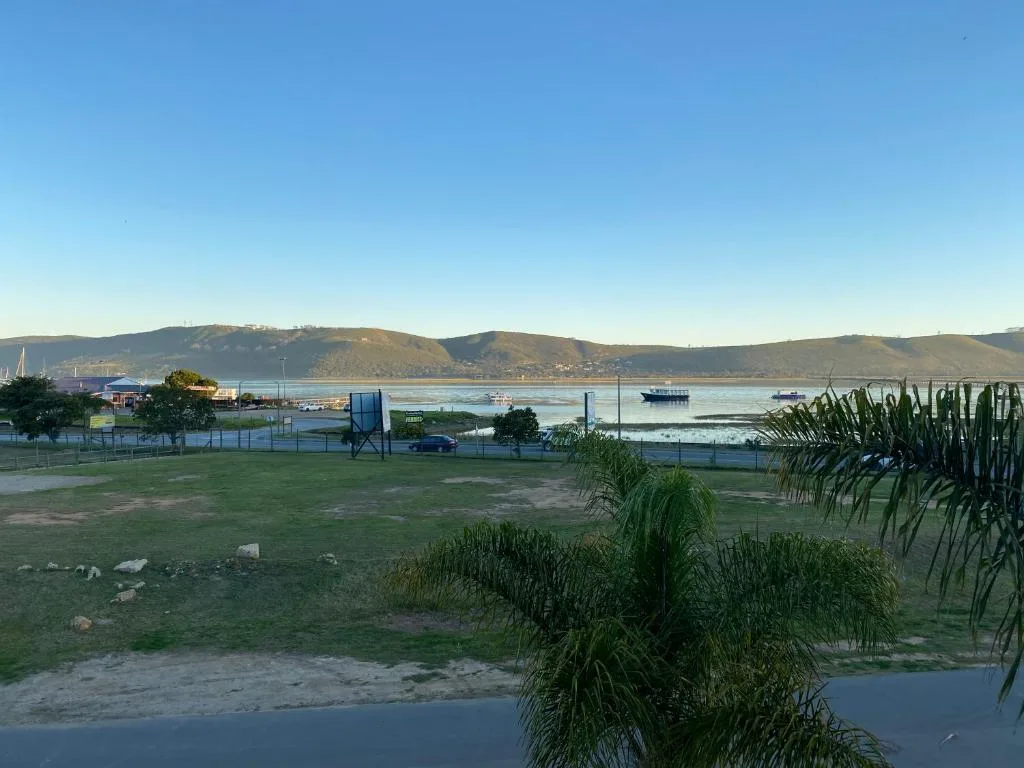 Scenic lagoon view with mountains, boats, and waterfront landscape