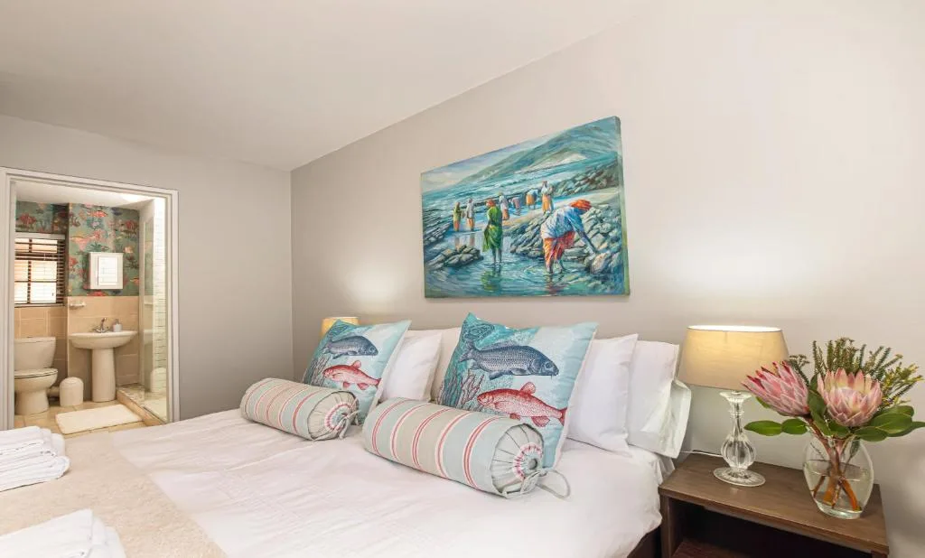 Bright bedroom with coastal-themed decor and fish-patterned pillows