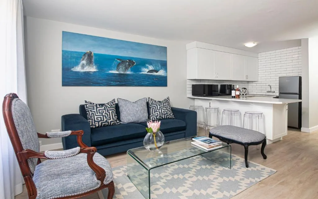Modern lounge with navy sofa, whale artwork, and open kitchen area