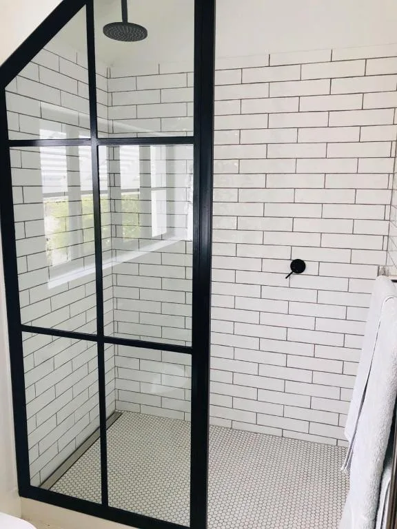 Modern shower enclosure with black frame and white subway tile walls