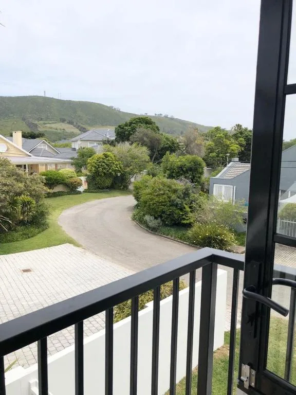 Scenic hillside view with manicured gardens and neighboring properties