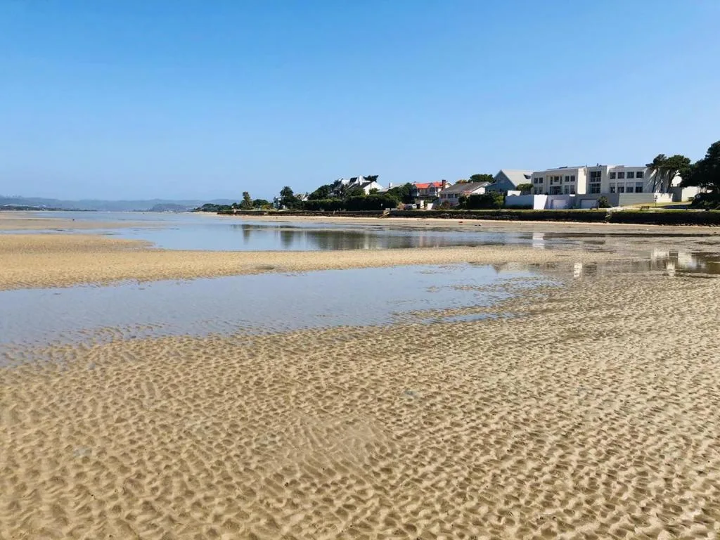 Beach and lagoon view with residential properties along the shoreline