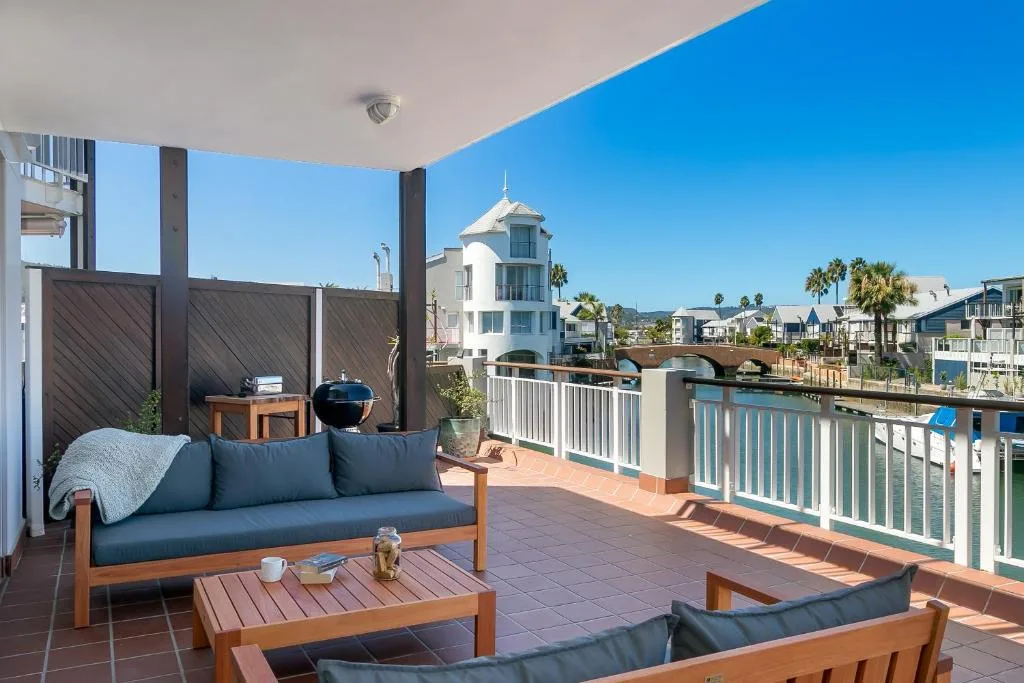 Spacious waterfront deck with wooden furniture and Knysna lagoon views