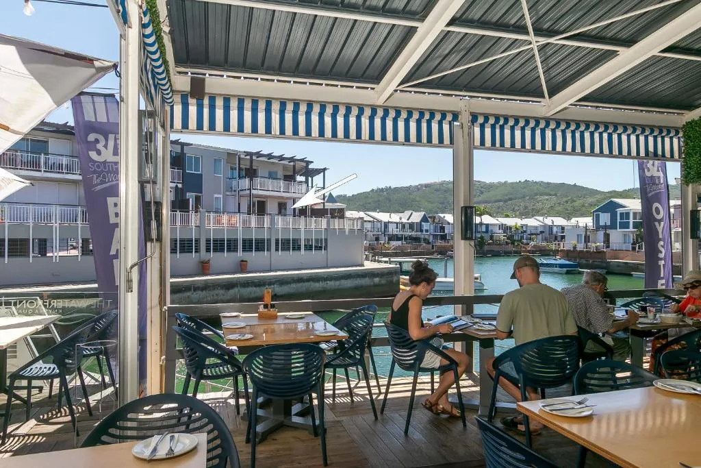 Waterfront dining deck with striped awning and lagoon views, Knysna