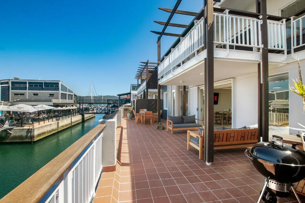 Spacious waterfront deck with braai, seating, and lagoon views