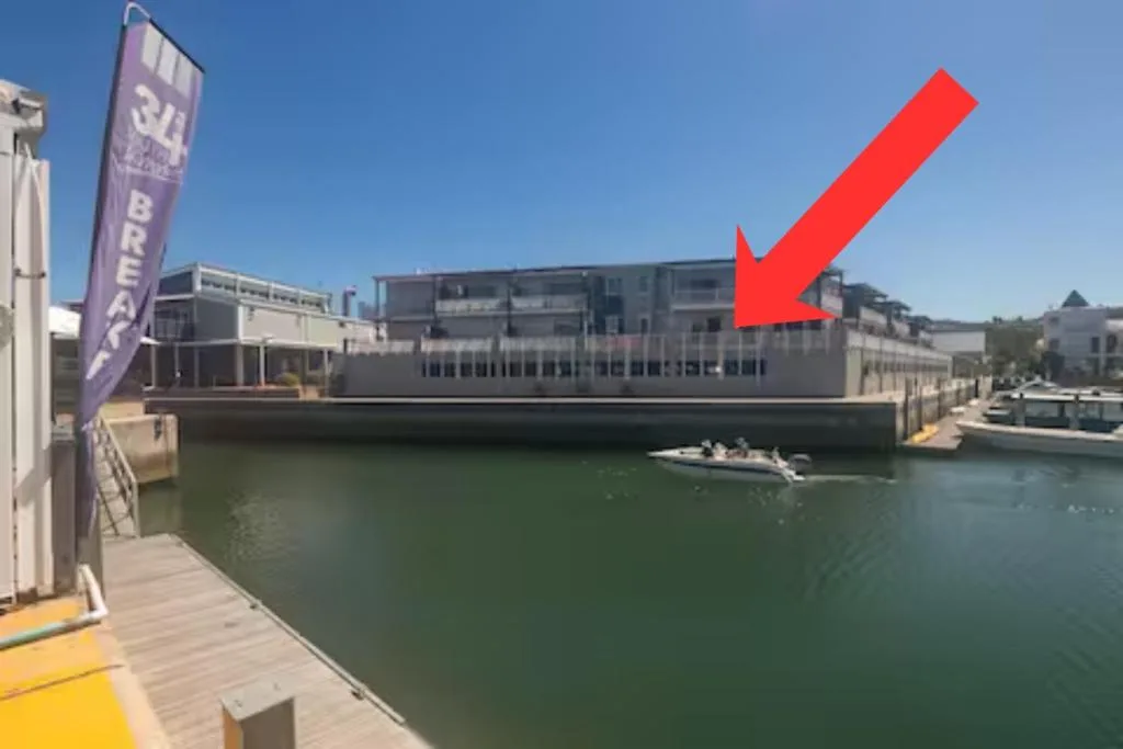 Modern waterfront apartment building with lagoon views and wooden deck