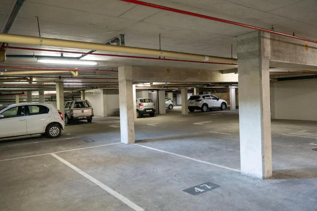 Secure underground parking garage with numbered spaces and concrete pillars