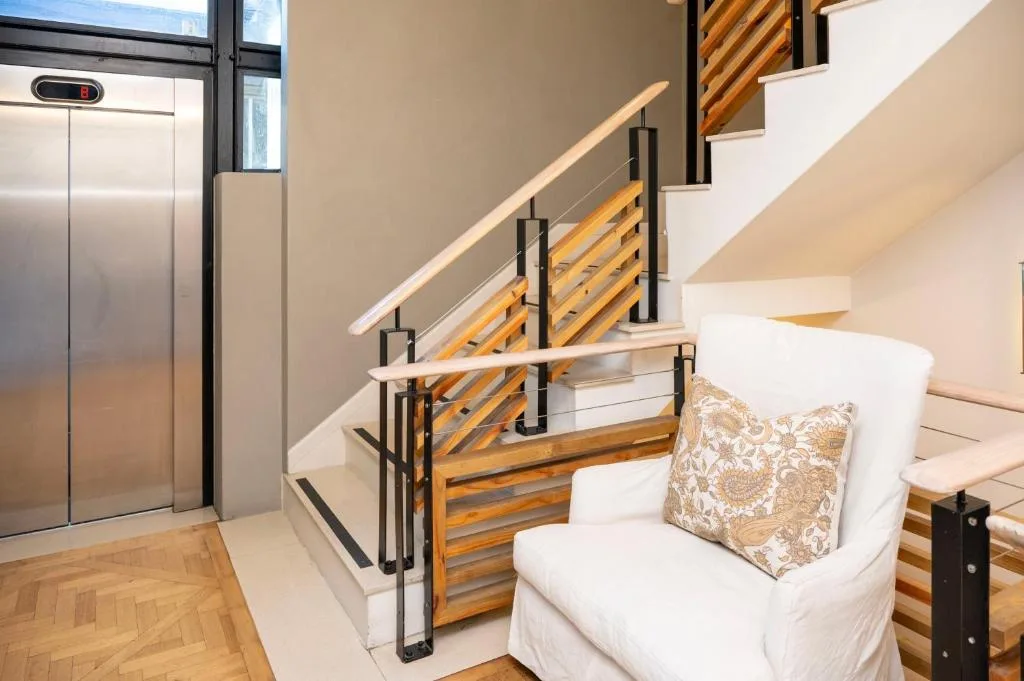 Modern staircase with wooden railings and white cushioned seating area
