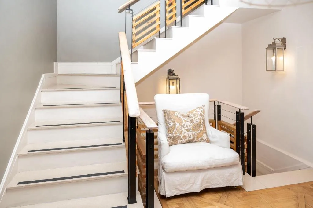 Modern staircase with white armchair and decorative lighting in hallway