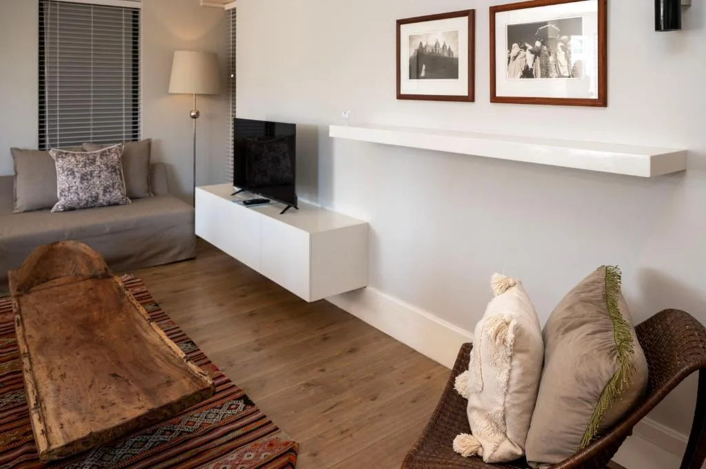 Modern lounge with sofa, TV, framed artwork, and contemporary furnishings