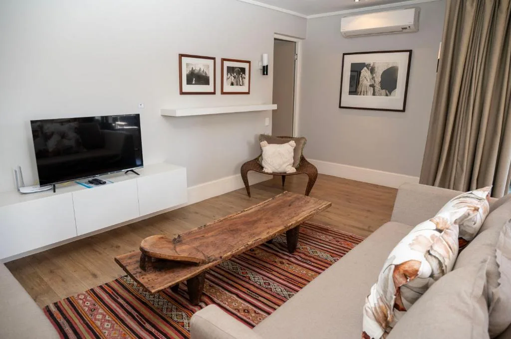 Modern living room with sofa, TV, wooden coffee table, and framed artwork