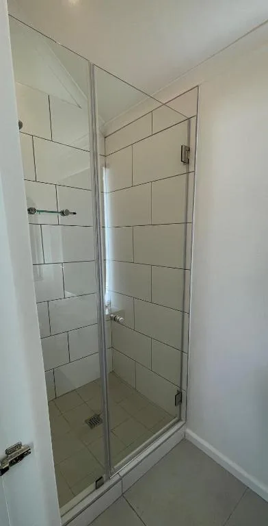 Modern walk-in shower with glass enclosure and subway tile walls