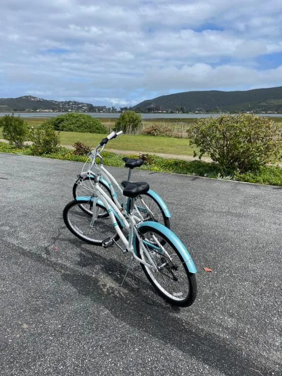 Blue and white bicycle on driveway overlooking lagoon and mountains