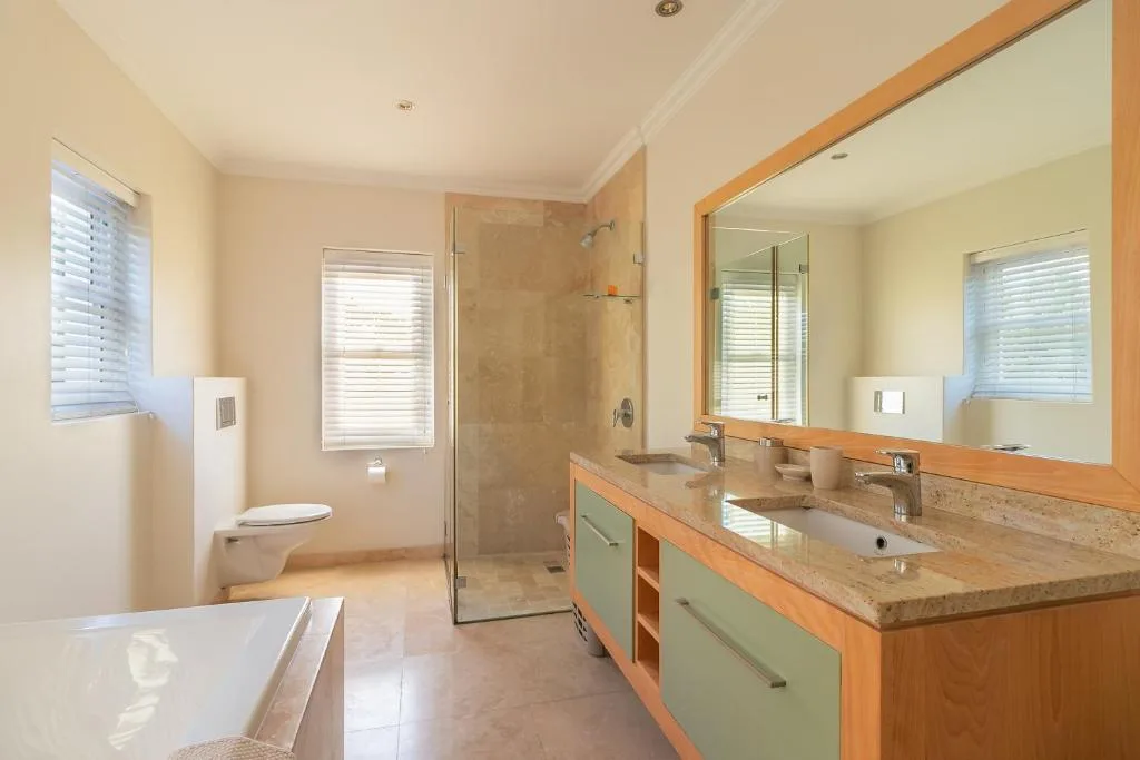 Spacious bathroom with double vanity, large mirror, and walk-in shower