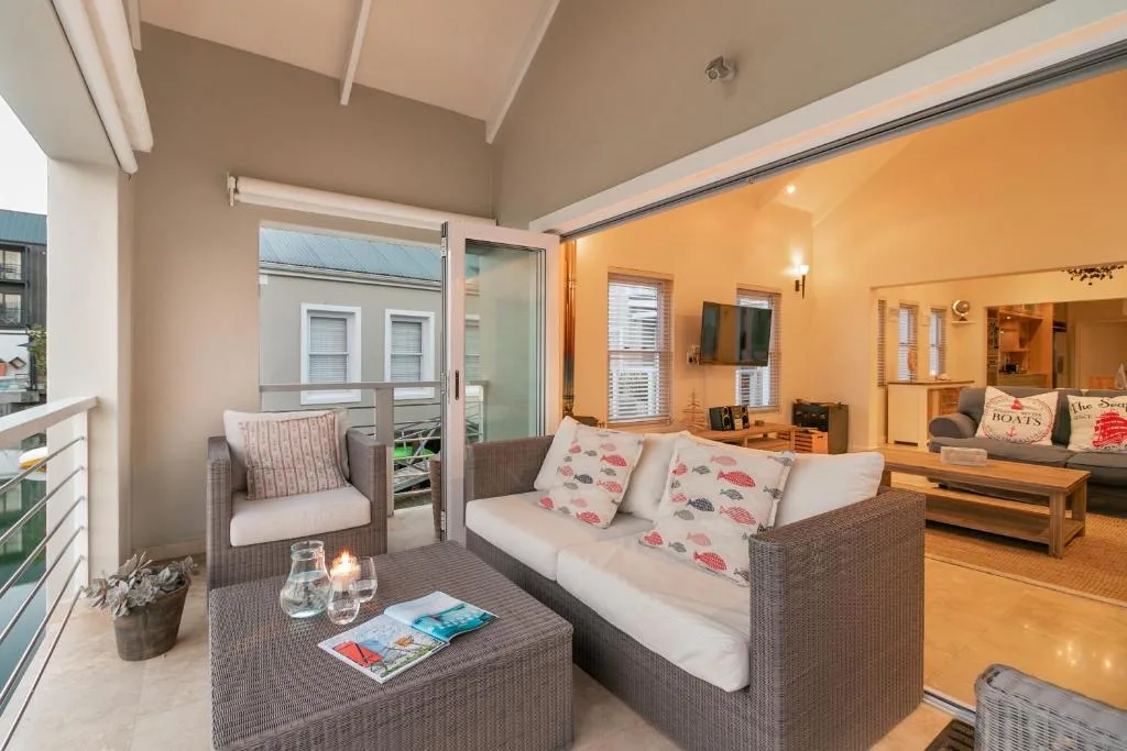 Covered outdoor seating area with wicker furniture and views to street