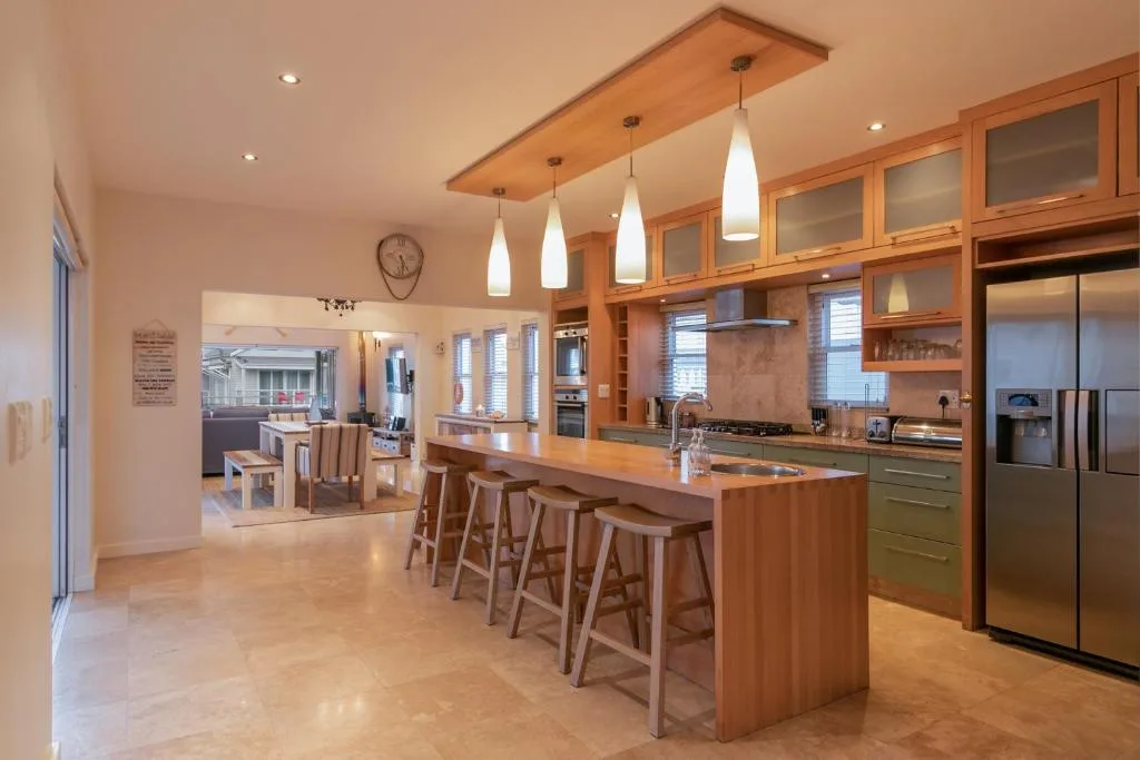 Modern kitchen with wooden island, pendant lighting, and stainless steel appliances