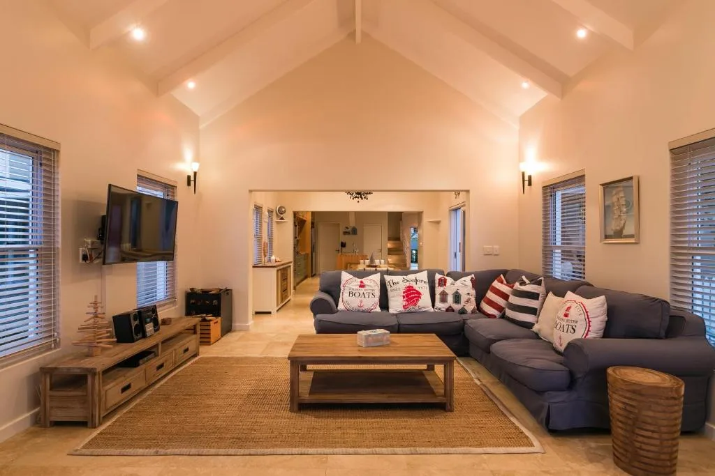 Spacious lounge with dark sectional sofa, coffee table, and wall-mounted television