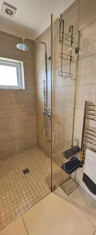 Modern walk-in shower with glass enclosure and rainfall showerhead