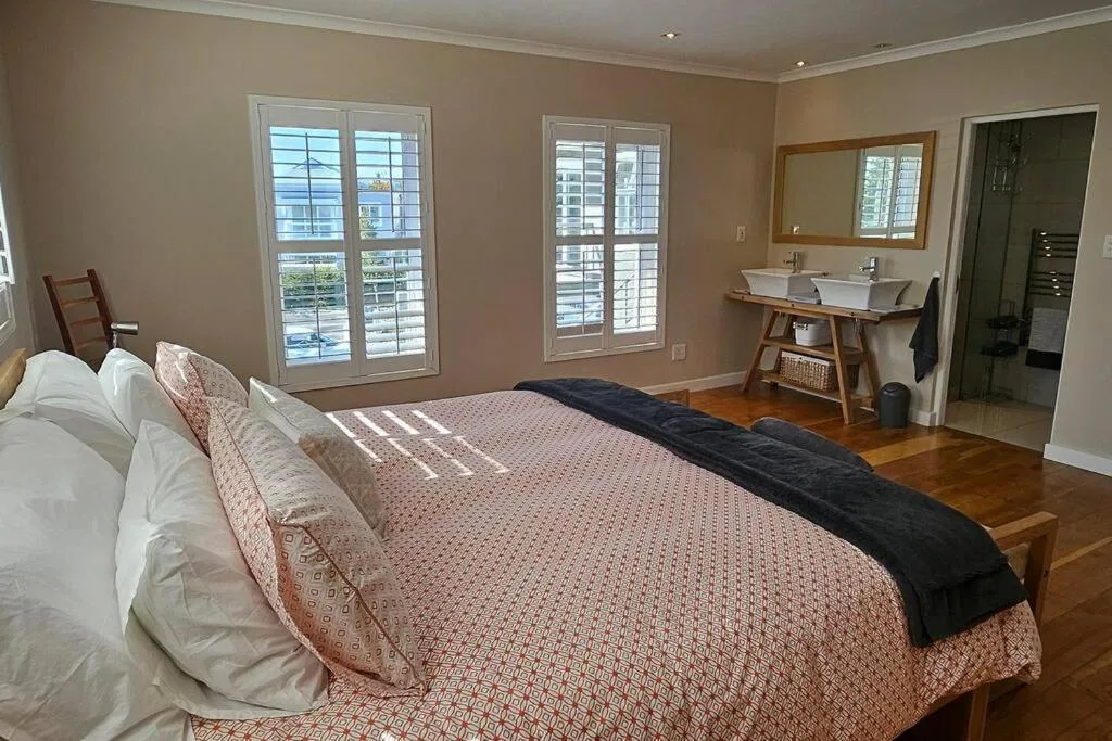 Spacious bedroom with queen bed, ensuite bathroom, water views through windows
