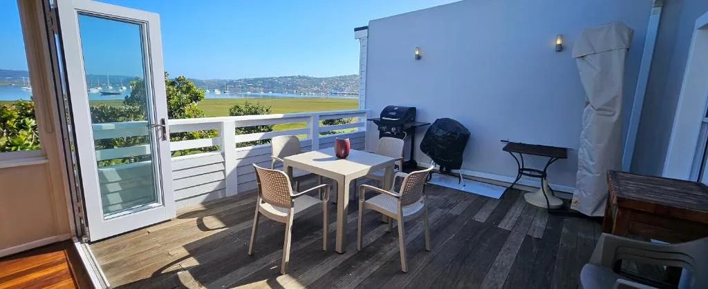 Outdoor deck with dining table overlooking lagoon and coastal town views