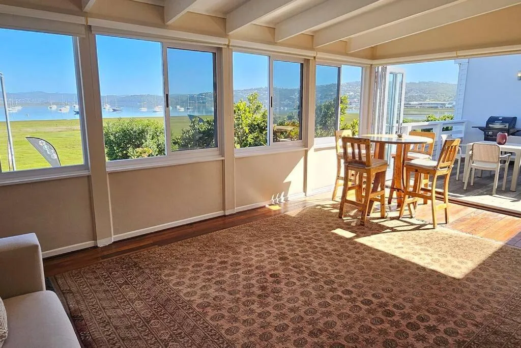Covered deck with dining table overlooking lagoon and mountains beyond
