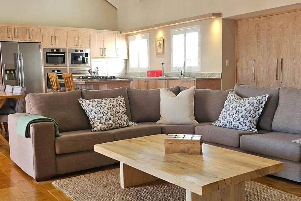 Spacious lounge with gray sectional sofa and wooden coffee table