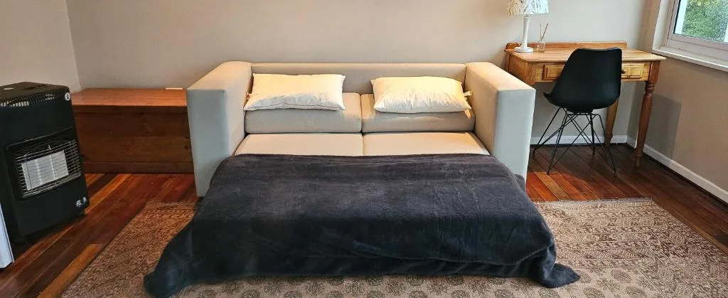 Comfortable gray sofa with cream pillows in bright, airy living room